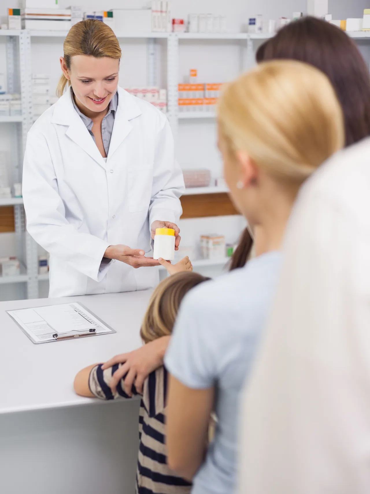 Balcão de farmácia pública com paciente aguardando dispensação de medicamento